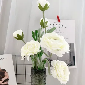 Detaillierte Nahaufnahme des künstlichen weißen Kamelien-Blumenstraußes in einer dunklen Vase.