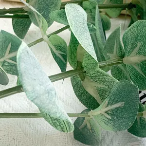 Detailaufnahme von künstlichen Eukalyptusblättern, realistisches Grün für Heim- und Hochzeitsdeko.