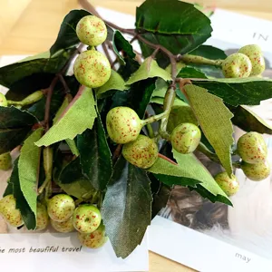 Nahaufnahme künstlicher grüner Beeren Zweige mit realistischen bunten Früchten und Blättern.