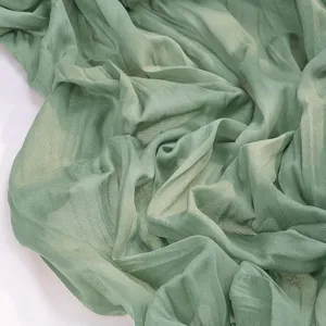 Detailed view of sage green crinkle voile table runner, elegant wedding party decor fabric.