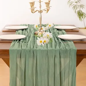 Detailed view of the crinkled green gauze table runner creating a luxurious and elegant dining setup.
