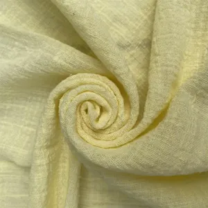 Yellow textured fabric napkin detail, wrinkled cotton gauze table decor cloth for weddings.