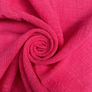 Close-up of bright pink wrinkled fabric napkin, textured spiral display for party table decor.