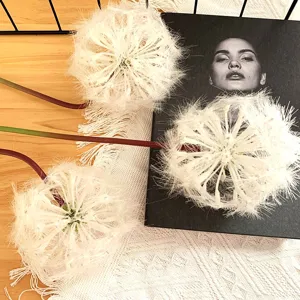 Closeup artificial white dandelion flowers home decor wedding floral arrangement detail shot.
