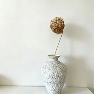 Close up detail of modern minimalist white ceramic vase with dried flower home decor.