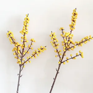 Close-up detail of artificial yellow berry branches, realistic winterberry decor for floral styling.