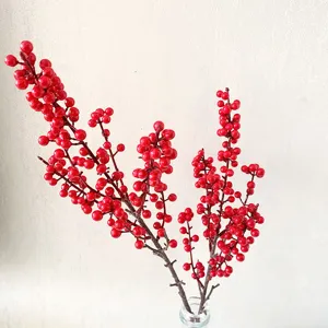 Detail shot of artificial red berry branches in a glass vase, perfect for home decor display.