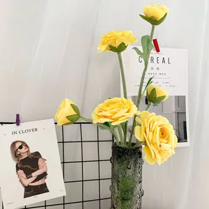 Künstlicher gelber Kamelien Tee-Rosen Blumenstrauß mit dunkler Vase für die Heimdekoration.