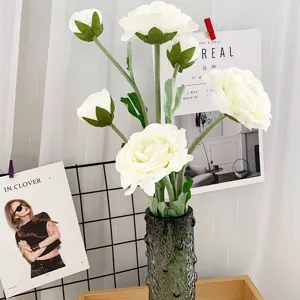 Künstlicher weißer Kamillenblumenstrauß in grünem strukturiertem Glasvase für Raumdekoration