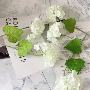 Artificial white hydrangea flower stem with green leaves for wedding decor and photo props.