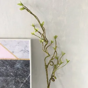 Artificial vine tree branch home decor detail view, realistic green leaves for room interior.