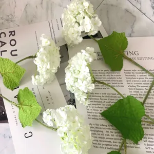 Artificial single white hydrangea flower with green leaves for wedding floral arrangement.