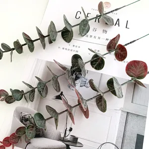 Detalle de rama de eucalipto artificial, planta verde falsa decorativa para el hogar.