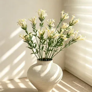 Artificial flower bouquet in white ceramic vase, modern light luxury home decor display.