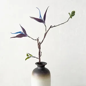 Branche de fleur artificielle avec vase en céramique pour décoration intérieure moderne.