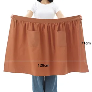Vista dettagliata del grembiule vintage in cotone con doppie tasche e larghezza 128cm.