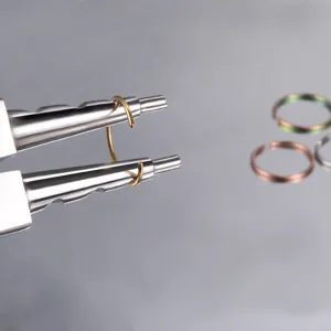 Nahaufnahme von Edelstahlnas Piercingring und Formwerkzeug, glänzendes Metallfinish Detail.