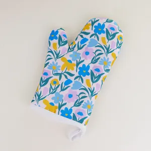 Floral pattern oven mitt detail view, showing charming blue and yellow flowers with green leaf print.