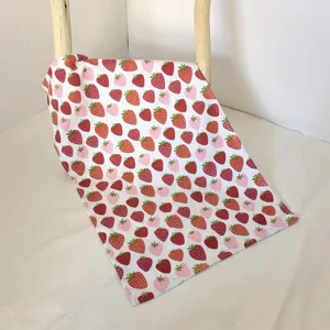 Detailed view of a soft cotton kitchen dish towel featuring a charming red and pink strawberry print.