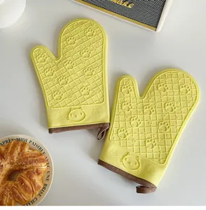 Vista dettagliata di guanti da forno in silicone giallo con zampa di gatto, resistenti.