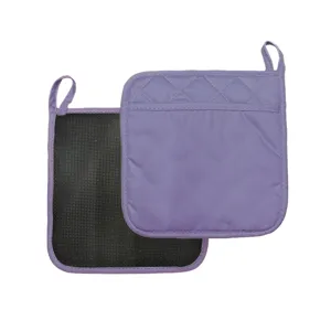Close-up detail of purple quilted pot holder with black non-slip backing and hanging loop.