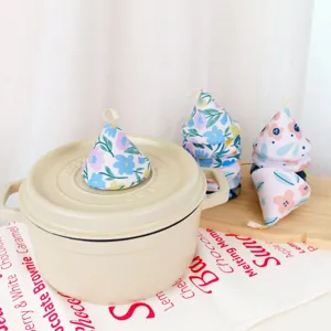 Detailed view of pastoral floral fabric pot handle covers, heat insulating kitchen mitts.