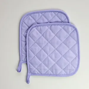 Détail de manique carrée matelassée montrant le tissu lavande et les coutures solides.