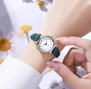 Women quartz watch detail shot featuring a dark green leather strap and white dial with numbers.