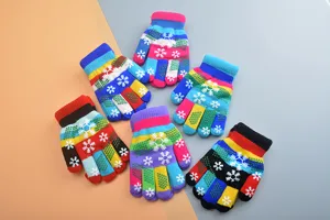 Detailed view of children's colorful knitted winter gloves with cute snowflake patterns and warm.