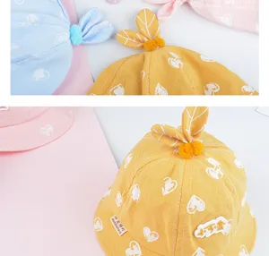 Baby bucket hat detail showing cute heart print, leaf top decoration, and soft cotton fabric.