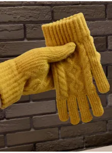 Detail view of winter warm yellow knitted wool gloves with cable pattern for cold weather.