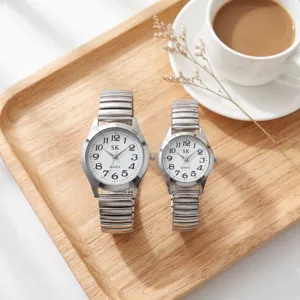 Detail shot of silver quartz couple watches with large numbers and expanding metal strap on tray.