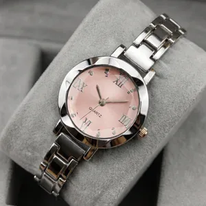 Gros plan détaillé d'une montre à quartz pour femme au cadran rose et bracelet en acier.