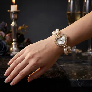 Elegant women's quartz watch with heart-shaped rhinestone dial and elastic pearl bracelet.