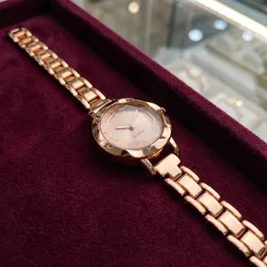 Gros plan d'une montre quartz pour femme en or rose avec bracelet en acier élégant.