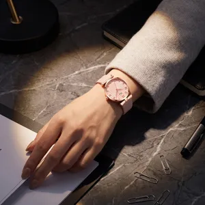Orologio al quarzo da donna elegante con quadrante rosa e fiocco, dettaglio su scrivania.