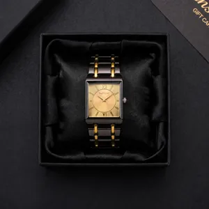 Detail view of rectangular quartz watch with gold dial, two-tone strap in luxury black box.