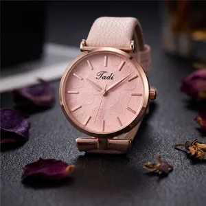 Close up of pink leather strap women quartz watch detail with leaf texture dial and bow