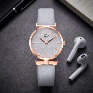 Women's quartz watch with grey leather strap leaf embossed dial and rose gold bow detail.
