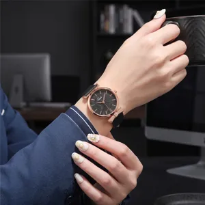 Detailed close-up of women's quartz watch featuring black leather strap and leaf dial.