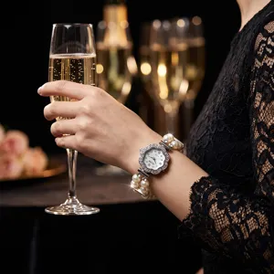Detailed shot of flower-shaped rhinestone quartz watch with double-row pearl elastic strap.