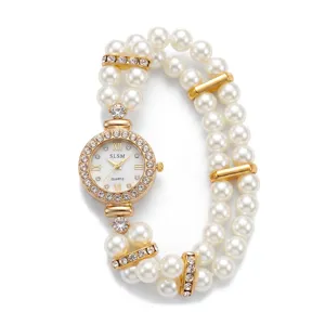 Detailed close-up of gold quartz watch with double-row faux pearl elastic bracelet and rhinestones.