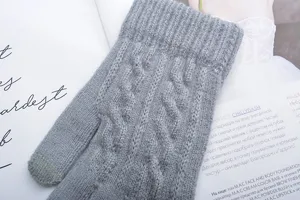 Close-up of gray women winter knit touchscreen gloves with cable knit design detail.