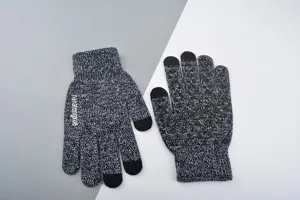 Gros plan sur des gants tactiles en tricot noir et blanc avec des points antidérapants.