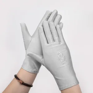 Detail view of summer thin sun protection gloves, white spandex driving gloves with floral embroidery.