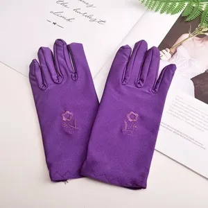 Detail view of purple summer thin women sunscreen gloves with cute embroidered flower decoration.