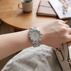 Detailed close-up of women rhinestone quartz watch with sparkling steel strap in silver color.