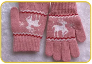 Detailed view of children's pink knitted winter gloves featuring cute deer and snowflake patterns.