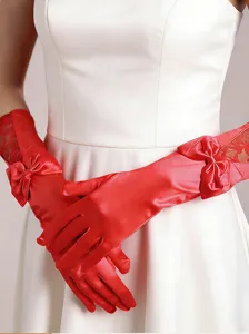 Detail shot of elegant red satin long gloves featuring delicate lace panels and cute ribbon bows.