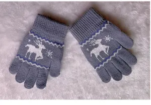 Detailed close-up view of grey winter knitted children warm gloves with cute deer pattern.
